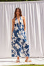 Woman wearing a blue floral dress standing against a white backdrop