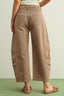 Brown wide-leg pants worn by a person on a light green background