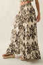 Woman wearing a floral patterned skirt on a plain background