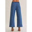 Blue jeans worn by a person on a plain background