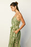 Woman wearing a green and white patterned dress against a plain background