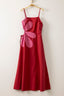 Red dress with pink floral accents on a hanger against a white background