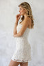 Woman wearing a white lace dress against a light gray background