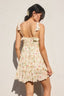 Woman wearing a floral dress against a plain background