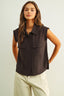 Woman wearing a brown sleeveless shirt with pockets on a light background