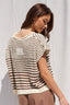 Woman wearing a striped sweater against a plain background