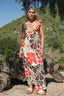Woman in a floral dress standing outdoors with a natural background