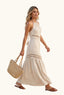 Woman in a coastal beige halter cut out maxi dress