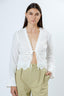 Woman wearing a white lace top and beige pants on a white background