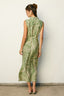 Woman wearing a green and white patterned dress against a plain background