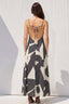 Woman wearing a black and white patterned dress with a white background