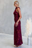 Woman wearing a burgundy lace dress against a gray background