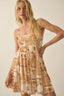 Woman wearing a patterned dress against a plain background