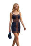 A woman walking down a city street wearing a navy blue mini dress with orange geometric stripe patterns. She is holding a matching navy blue handbag.