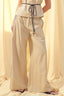 Beige pants with a drawstring waist on a neutral background