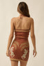 Woman wearing a brown dress with animal prints on a beige background