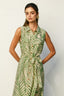 Woman wearing a green and white patterned dress against a plain background