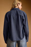 Person wearing a navy blue shirt against a brown background