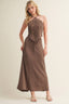 Woman wearing a brown dress with a textured top and plain skirt on a beige background