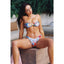 Woman wearing a colorful bikini sitting outdoors.