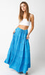 Woman wearing a white top and blue tiered skirt on a white background