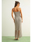 Woman wearing a long, patterned dress with a plain background