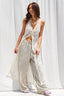 Woman wearing a white lace cover-up over striped pants against a white background