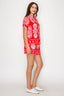 Woman wearing a red set with white floral patterns on a white background