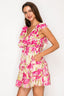 Woman wearing a pink floral dress against a white background